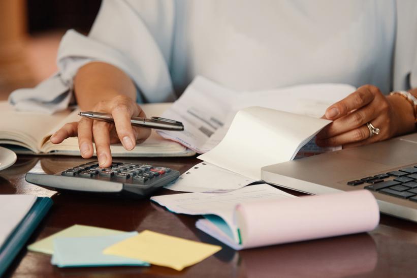Person sits at a desk calculating bills