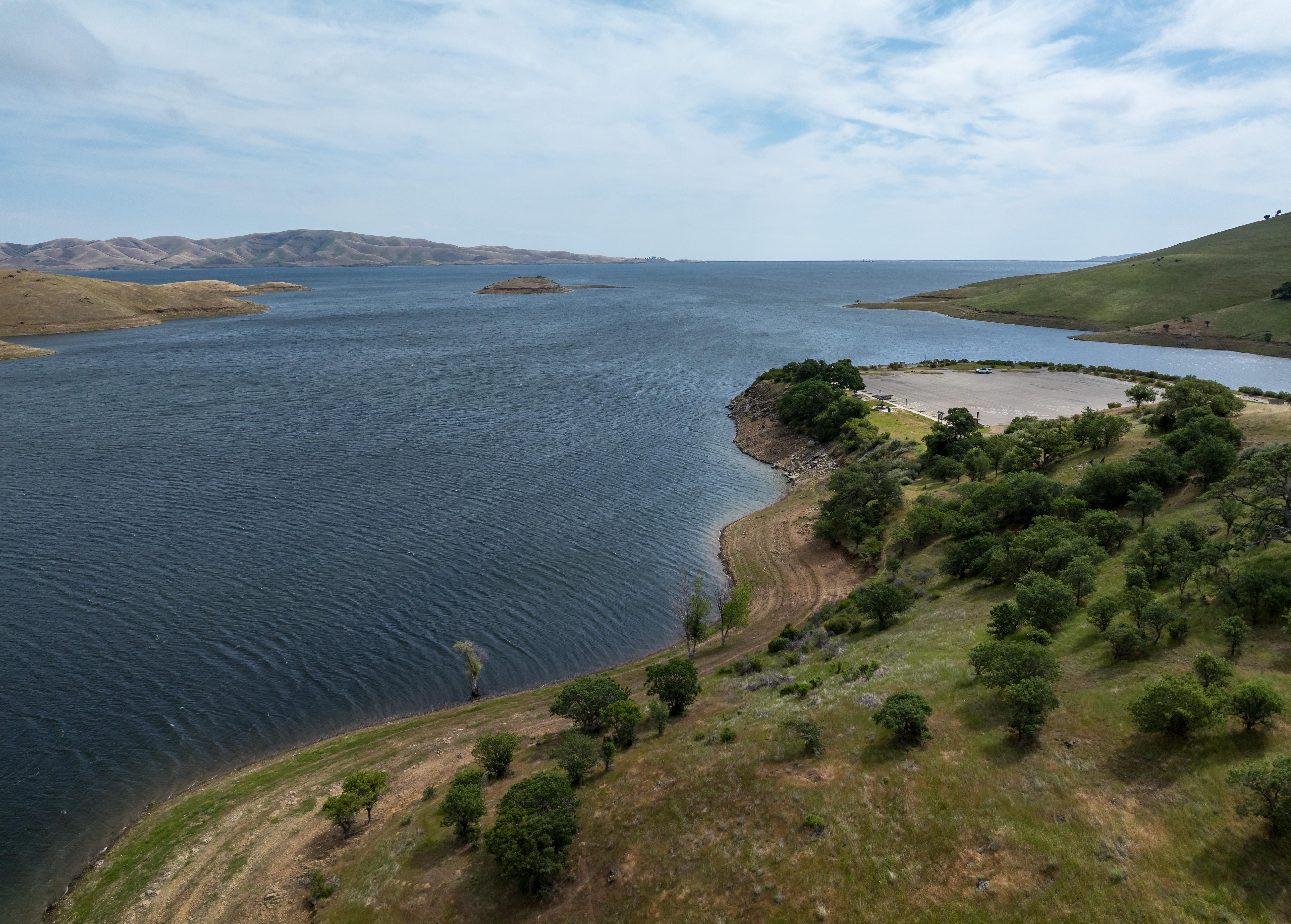 An aerial view from a drone shows green vegetation around Dinosaur Point Boat Launch Ramp and high lake levels at San Luis Reservoir on April 15, 2025. On this date, the reservoir storage was 1,805,235 AF, or 88 percent of the total capacity. Photo courtesy of Xavier Mascareñas / California Department of Water Resources.