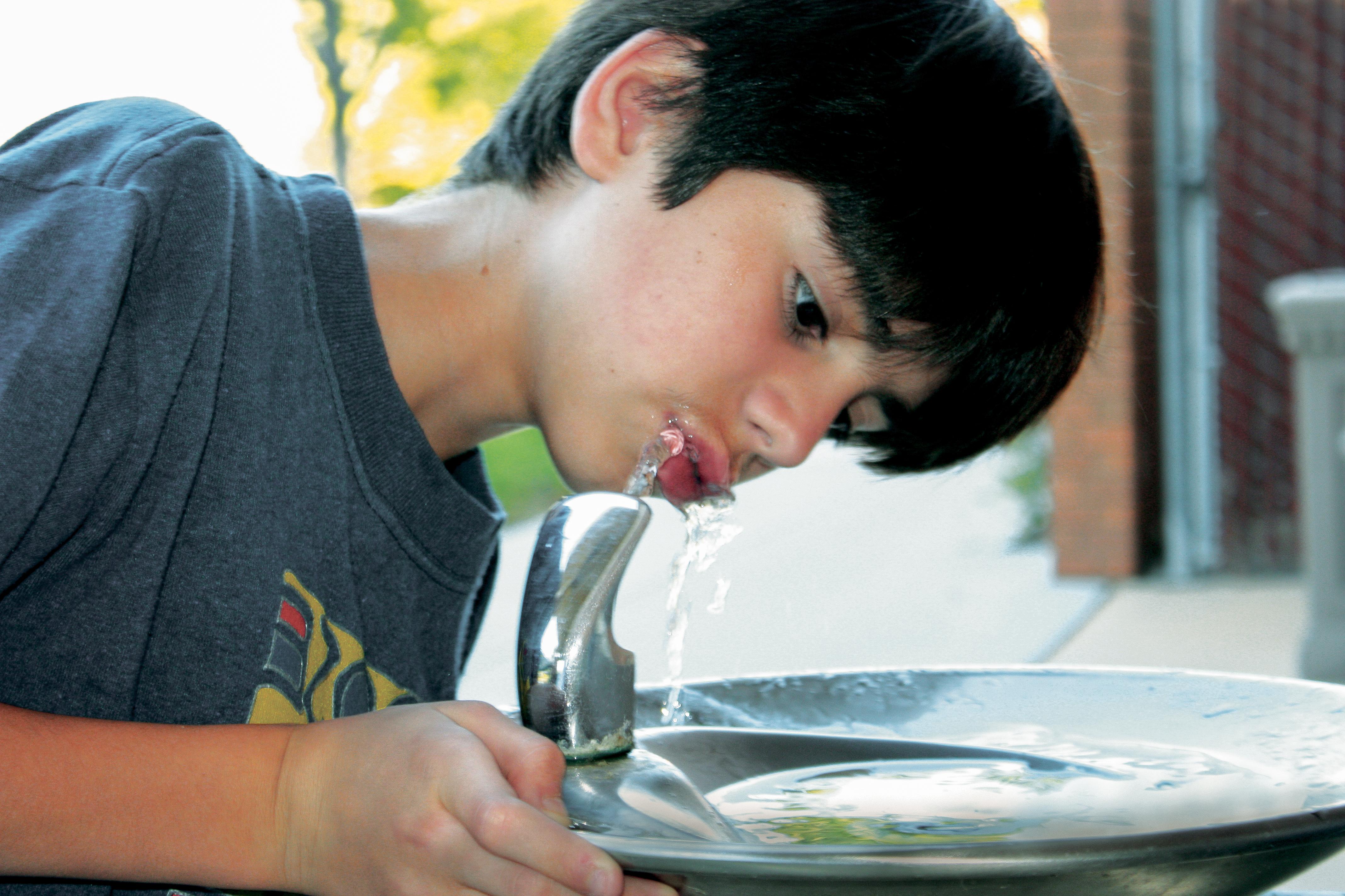 Boy drinking water from fountain